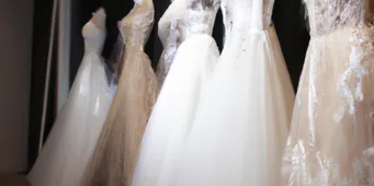 Affordable wedding dresses displayed in a boutique, featuring delicate lace and flowing fabrics, perfect for a budget-conscious bride.
